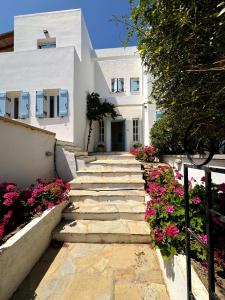 a stone path leading to a white building with flowers at Villa Vivi in Finikas