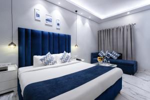 a bedroom with a large bed and a blue headboard at Hotel Downtown 17 in Chandīgarh