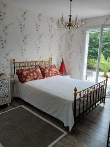 a bedroom with a bed with white sheets and red pillows at Les vignobles du Bordelais in Montussan