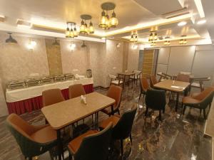 a restaurant with tables and chairs and a bar at Hotel Aman Residency in Allahābād