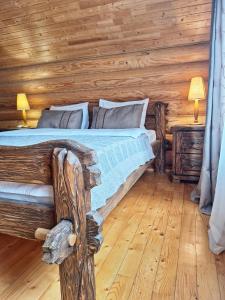 ein Schlafzimmer mit einem Bett in einem Blockhaus in der Unterkunft Khytir Falchi in Mykulytschyn