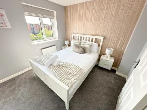 a bedroom with a white bed and a window at Luxury 4 Bed House - Free Parking - Contractors - Relocators in Newcastle upon Tyne