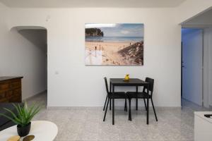 a dining room with a table and a picture of a beach at Modern Comfort App in Las Palmas GC in Las Palmas de Gran Canaria