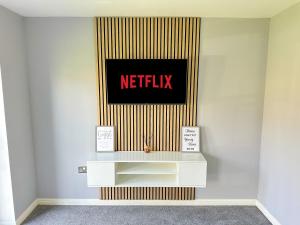 eine Wand mit einem Netflix-Schild an der Wand in der Unterkunft Luxury 4 Bed House - Free Parking - Contractors - Relocators in Newcastle upon Tyne