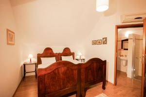 a bedroom with a wooden bed and a bathroom at Dom gościnny w Bartniku in StrÃ³Å¼e