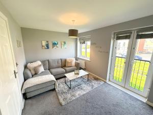 a living room with a couch and a table at Luxury 4 Bed House - Free Parking - Contractors - Relocators in Newcastle upon Tyne