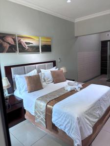 um quarto com 2 camas e lençóis brancos em The Pillows Suite em Pretoria