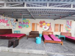 une terrasse avec bancs et un mur orné de graffitis dans l'établissement Mui Ne Hills Backpackers, à Mui Ne
