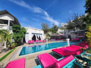 a swimming pool with pink lounge chairs and a swimming pool at Mui Ne Hills Backpackers in Mui Ne