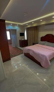 1 dormitorio con 1 cama y TV en شقة فندقية مميزة بالمنصورة, en Ṭalkha