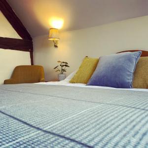 a bedroom with a bed with blue sheets and a lamp at The Talbot at Knightwick in Broadwas