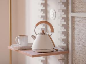 a tea kettle and a cup on a shelf at Hôtel Basss in Paris
