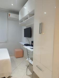 a bedroom with a bed and a desk with a computer at Quitinete ACONCHEGANTE in Rio de Janeiro