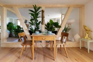 une salle à manger avec une table, des chaises et des plantes dans l'établissement Gantrisch Lodge Ottenleuebad, à Guggisberg