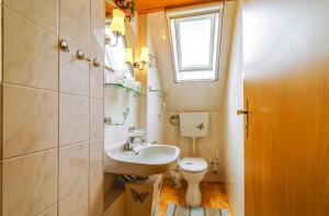 a small bathroom with a sink and a toilet at Ferienwohnungen im Deichweg in Zingst