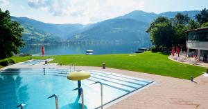 a swimming pool with a view of a lake and mountains at OTILIA apartment in Zell am See