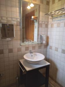 a bathroom with a sink and a mirror at Xenios Petritis in Levádeia