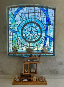 a stained glass window in a room with a shelf at Paka Apartment (Infinity Kira Island Apartment) in Watamu