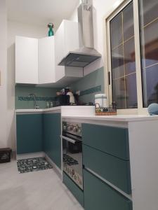 una cocina con armarios azules y blancos y fregadero en ThirtyOneB villetta in villaggio privato en Portoscuso