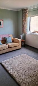 un soggiorno con divano e tappeto di The Annexe Cottage at Newhouse Farm a Lanark