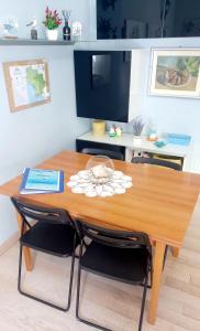 mesa de comedor con sillas y TV en La Casa di Barbanella, en Grosseto