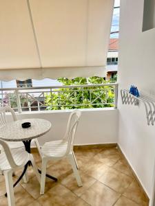 balcón con mesa, sillas y ventana en Hotel Aulona, en Sarandë