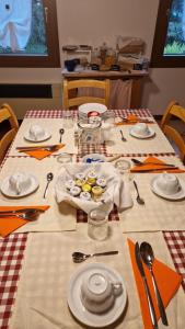 una mesa con platos y utensilios. en LE BETULLE B&B en Pove del Grappa