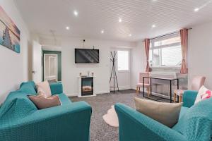uma sala de estar com cadeiras azuis e uma lareira em The Cottage at Logan Lodge em Great Yarmouth