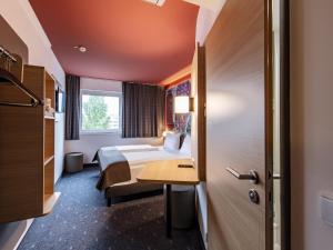 アッシュハイムにあるB&B HOTEL München-Messeのベッドとデスクが備わるホテルルームです。