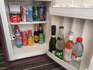 - un réfrigérateur rempli de bouteilles de soda et de boissons dans l'établissement Hôtel Harvey, à Paris