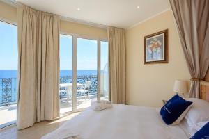 een slaapkamer met een bed en een groot raam bij Grand Hotel Mediterranee in Alassio