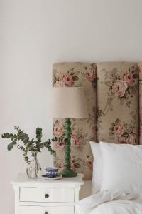 - une chambre dotée d'un lit avec une lampe et des fleurs dans l'établissement Le Petit Paris, à Franschhoek