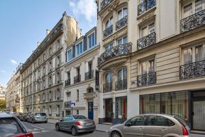 a street with cars parked in front of buildings at H&ocirc;tel Harvey in Paris