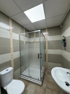 y baño con ducha, aseo y lavamanos. en D&M Apartments, en Struga