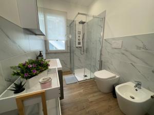 a bathroom with a toilet and a sink and a shower at Casa Belfiore Etna-apartments in Giarre +12 photos
