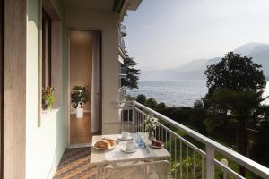 a table on a balcony with a view of the ocean at Vista Lago in Omegna