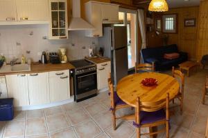 a kitchen with a wooden table and a kitchen with a table and chairs at Maison d'hôtes à la campagne in Labastide-dʼArmagnac +2 photos