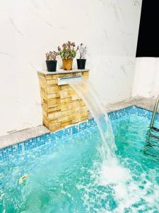 a water fountain in a swimming pool at HemaRay villa - luxury stay with pool in Chennai