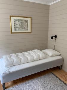 Bett in einem Zimmer mit einem Bild an der Wand in der Unterkunft Trysnes Brygge in Kristiansand
