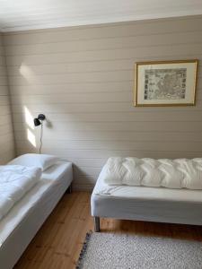 a bedroom with two beds and a rug and a picture at Trysnes Brygge in Kristiansand