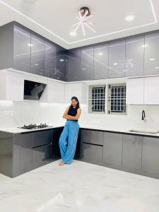 a woman standing in the middle of a kitchen at HemaRay villa - luxury stay with pool in Chennai