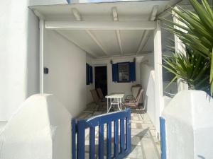 une terrasse couverte avec un banc bleu et une table dans l'établissement Elenitas beach house in Ornos, à Ornos