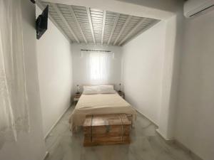 Cette petite chambre comprend un lit et une fenêtre. dans l'établissement Elenitas beach house in Ornos, à Ornos