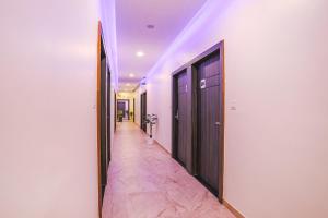 a hallway with two doors and a hallway with pink tiles at FabHotel Prime Ajinkya Palace in Aurangabad
