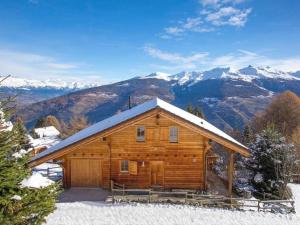 a log cabin in the snow with mountains in the background at Chalet Albert in Les Collons