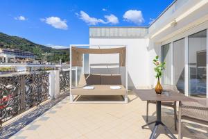 eine Terrasse mit einem Bett und einem Tisch auf dem Balkon in der Unterkunft Grand Hotel Mediterranee in Alassio