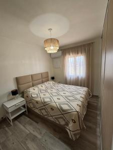 a bedroom with a bed and a chandelier at Lucia Guest House Beach - apartamento Family, Friends & Fun PET FRIENDLY in Málaga