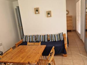 een woonkamer met een bank en een houten tafel bij Appartement Hyères, 2 pièces, 3 personnes - FR-1-335-161 in Hyères