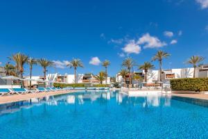 een groot zwembad met palmbomen en gebouwen bij Aaron Beautifull House in Arona