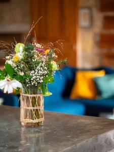 eine Vase voller Blumen auf einem Tisch in der Unterkunft La Grange des Anges in Blanc